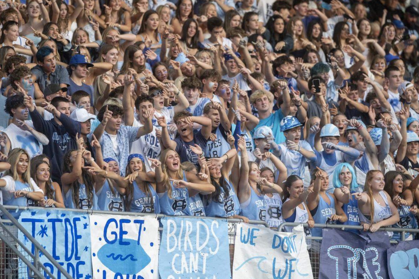 Darkened background photo: the Gig Harbor student section at the Fish Bowl