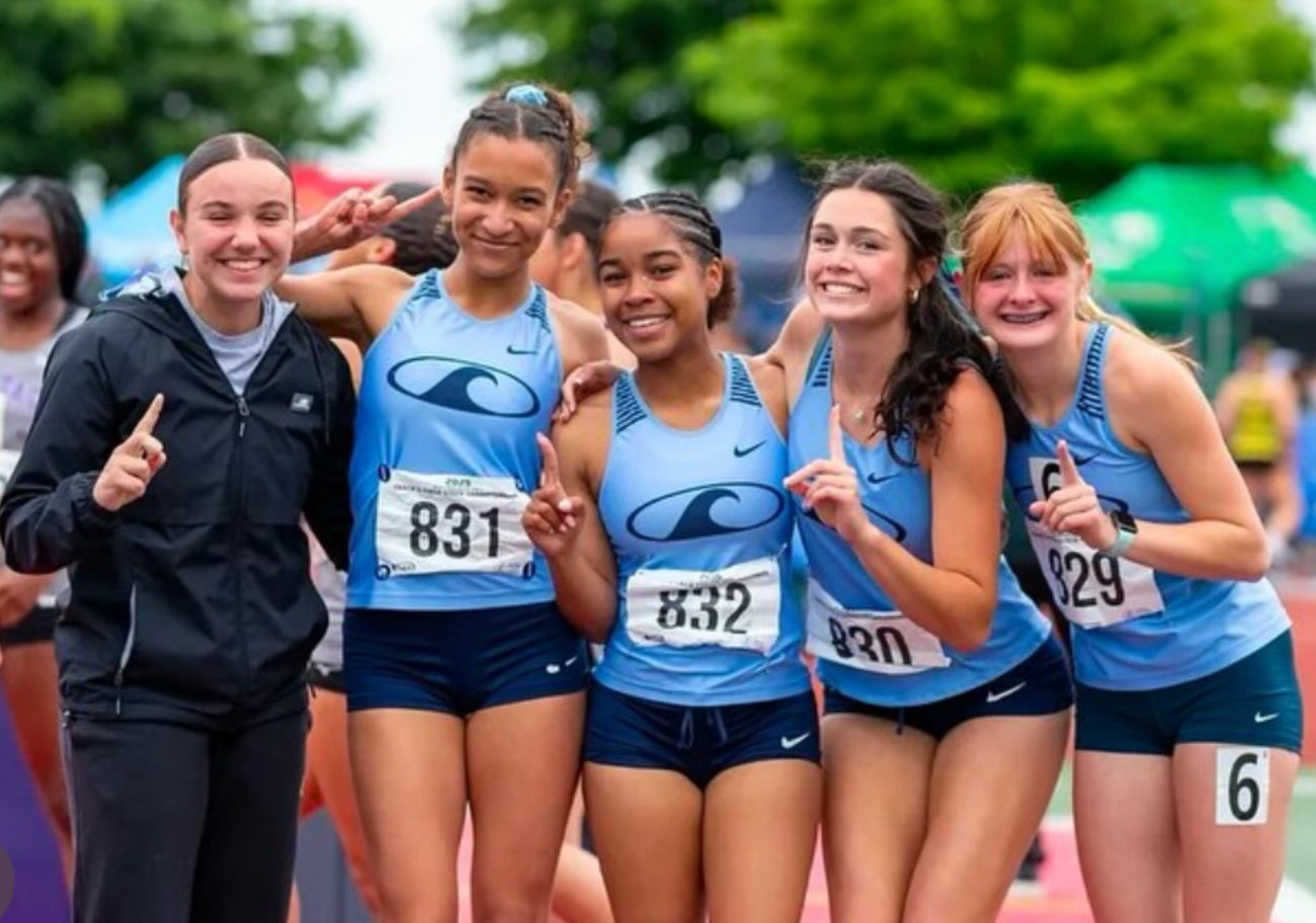 Darkened background photo: the Gig Harbor girls cross country team at a track meet